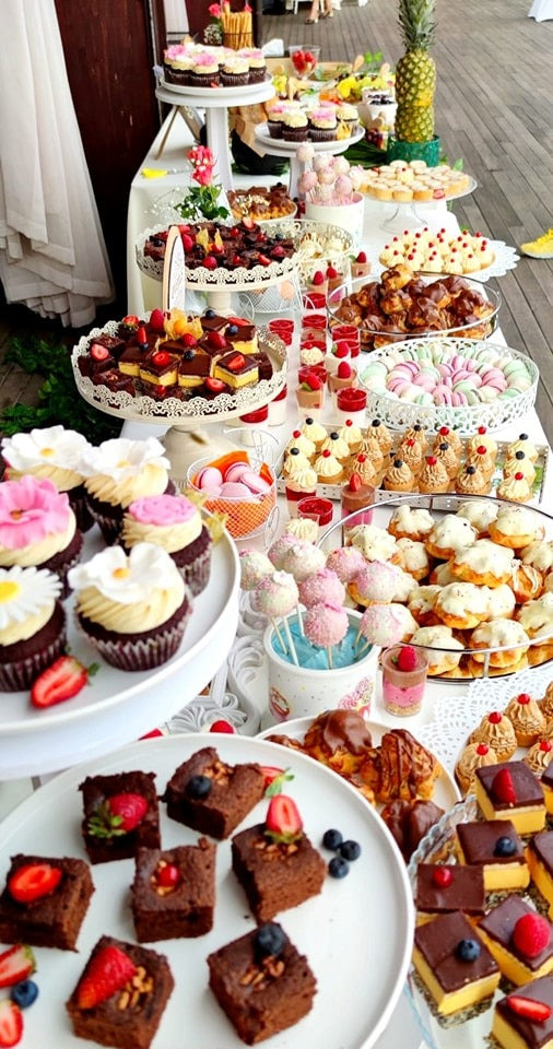 Candy bar elegant cu prăjituri variate, cupcakes, cake pops și macarons, aranjate tematic pentru un eveniment special în aer liber – Atelierul de Limonadă.