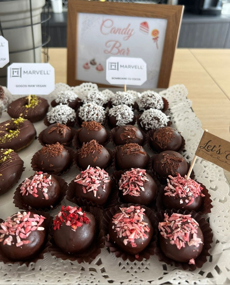 Bomboane raw vegane decorate cu fulgi de cocos, ciocolată rasă și fructe liofilizate, fără zahăr, gluten sau lactate.