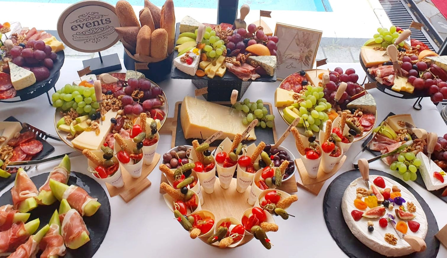 Cheese Bar pentru eveniment, cu platouri de brânzeturi, struguri, nuci, mezeluri fine, legume și gustări, amenajat lângă piscină.