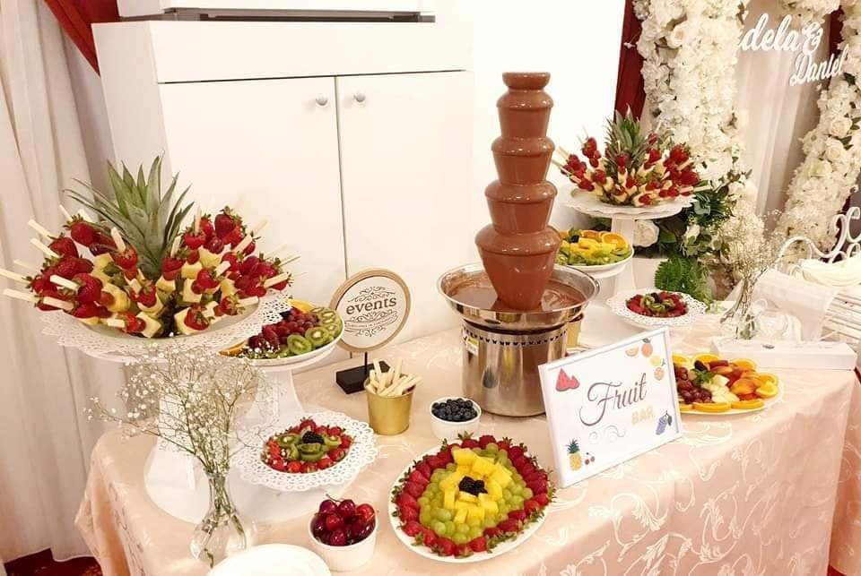 Fruit bar elegant cu fântână de ciocolată belgiană și mix variat de fructe proaspete, prezentat la un eveniment rafinat.