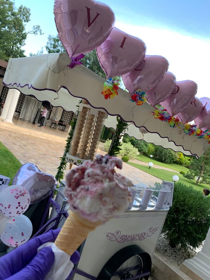 Înghețată servită în cornet în fața unui ice cream bar decorat cu baloane personalizate, ideal pentru petreceri cu tematică romantică sau aniversări speciale.