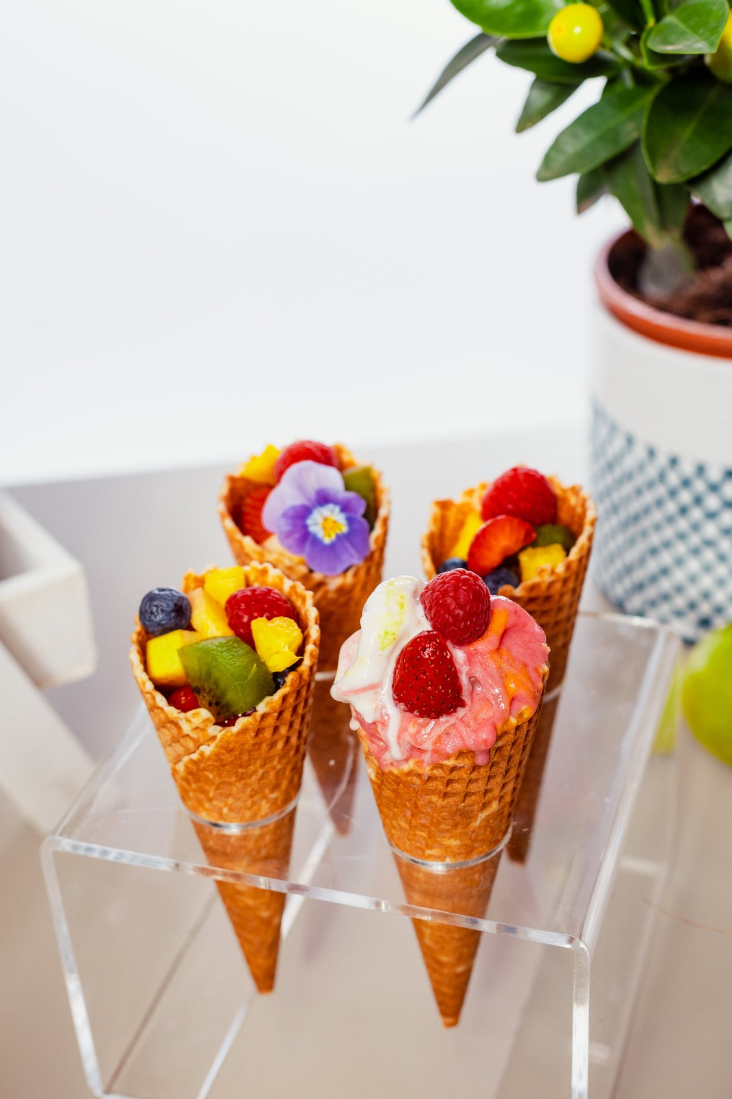 Cornete de înghețată din ice cream bar decorate cu fructe proaspete, flori comestibile și servite elegant pentru evenimente speciale precum nunți, botezuri sau petreceri corporate.
