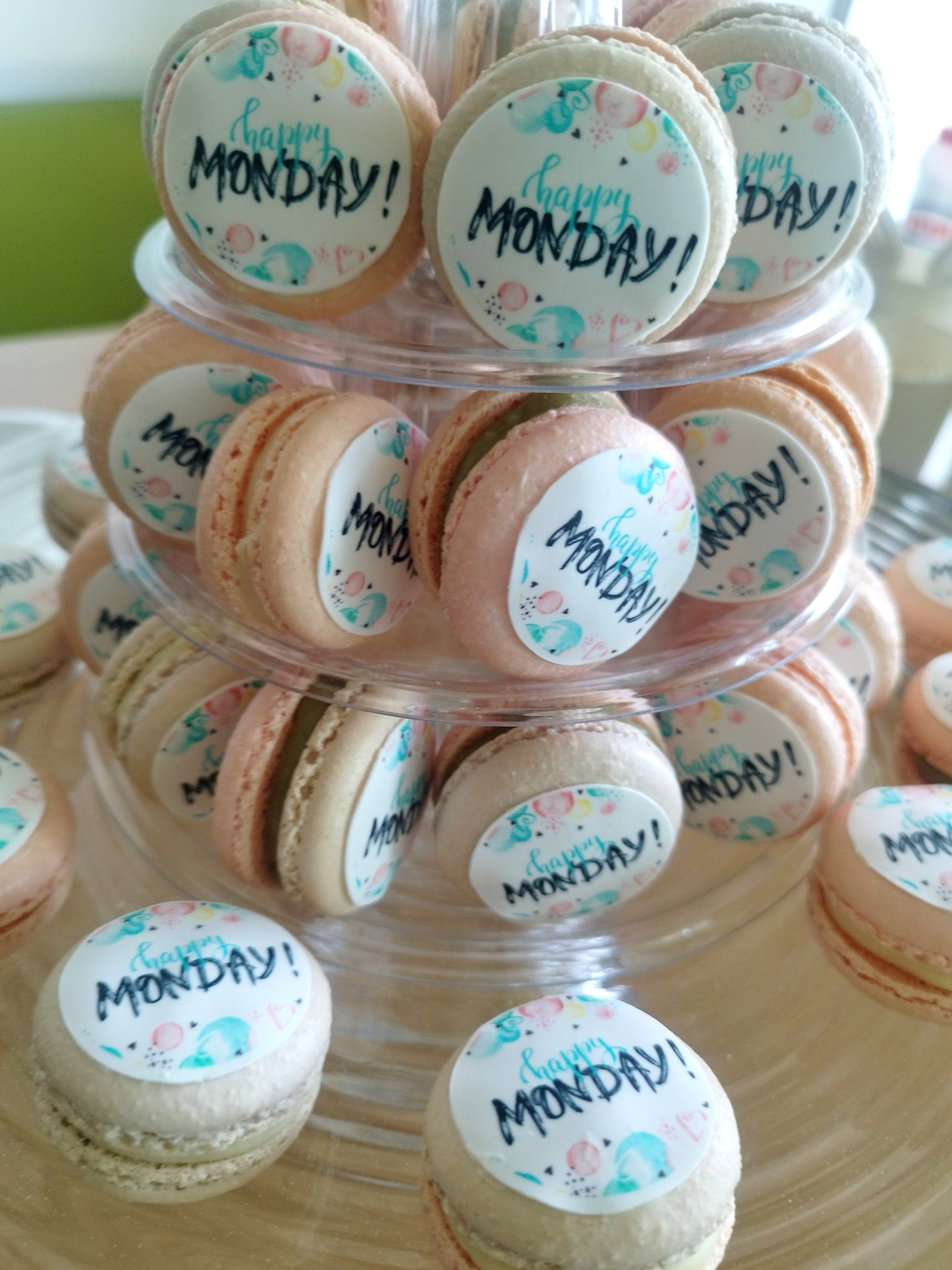 Close-up cu macarons personalizați cu logo și mesajul "Happy Monday", detalii dulci pentru evenimente corporate.