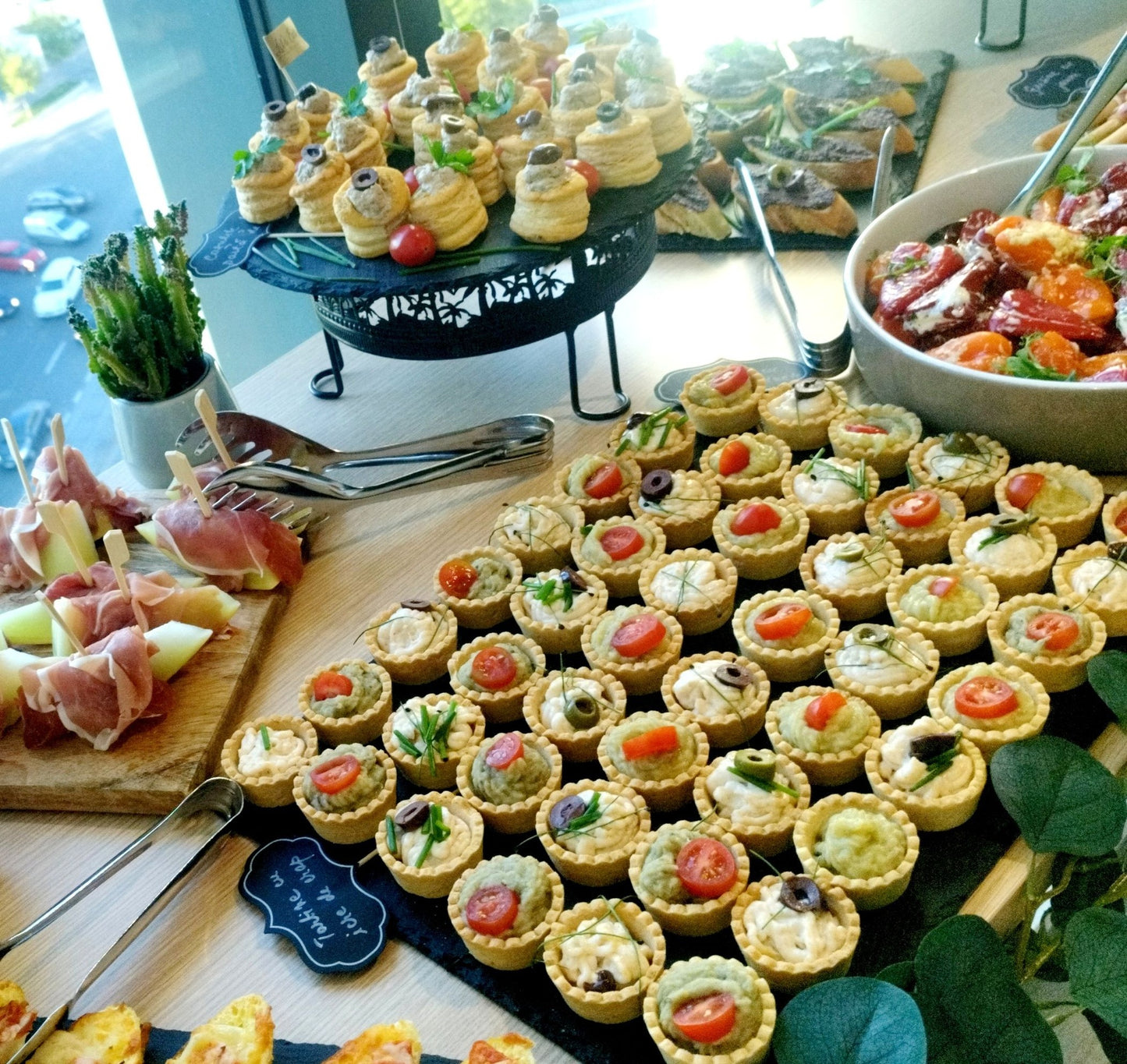 Platouri cu mix de aperitive: coșulețe cu cremă de brânză, măsline, roșii cherry, frigărui cu jamon și pepene galben, ardei kapia umpluți și vol-au-vent cu mousse.