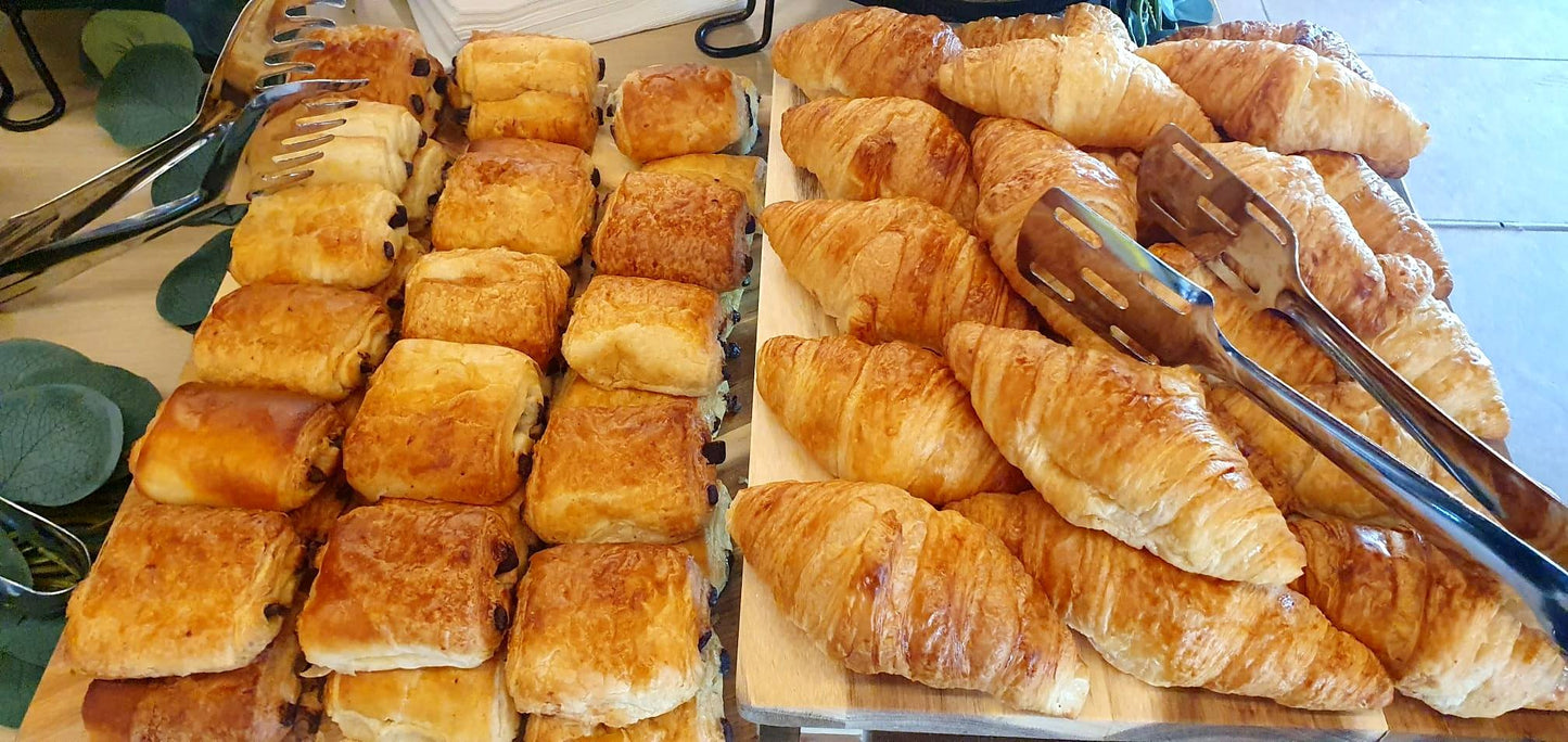 Platouri de patiserie pentru evenimente corporate, cu o selecție de croissante cu unt și pain au chocolat proaspăt coapte.