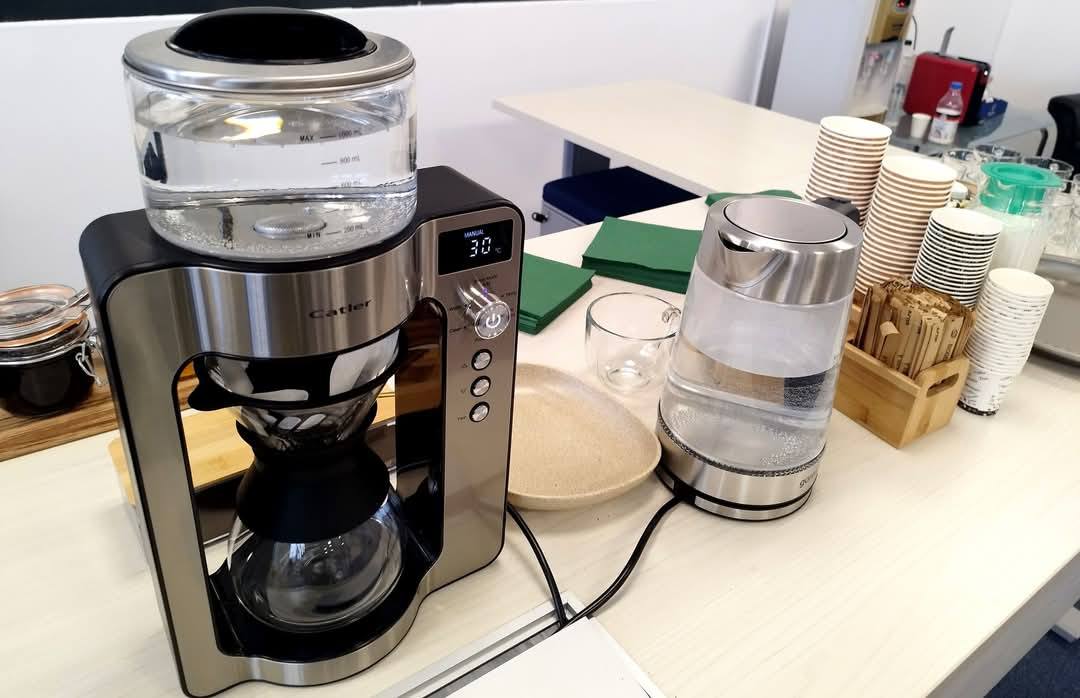 Stație de băuturi calde pentru evenimente corporate, cu filtru de cafea proaspăt preparată și fierbător de apă pentru ceai.