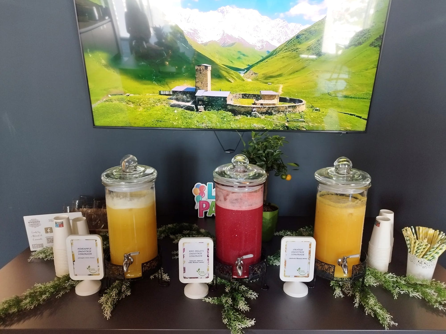 Prim-plan cu dispensere de smoothie de ananas și fructe de pădure, servite la un eveniment. Băuturi răcoritoare 100% naturale. | Atelierul de Limonadă