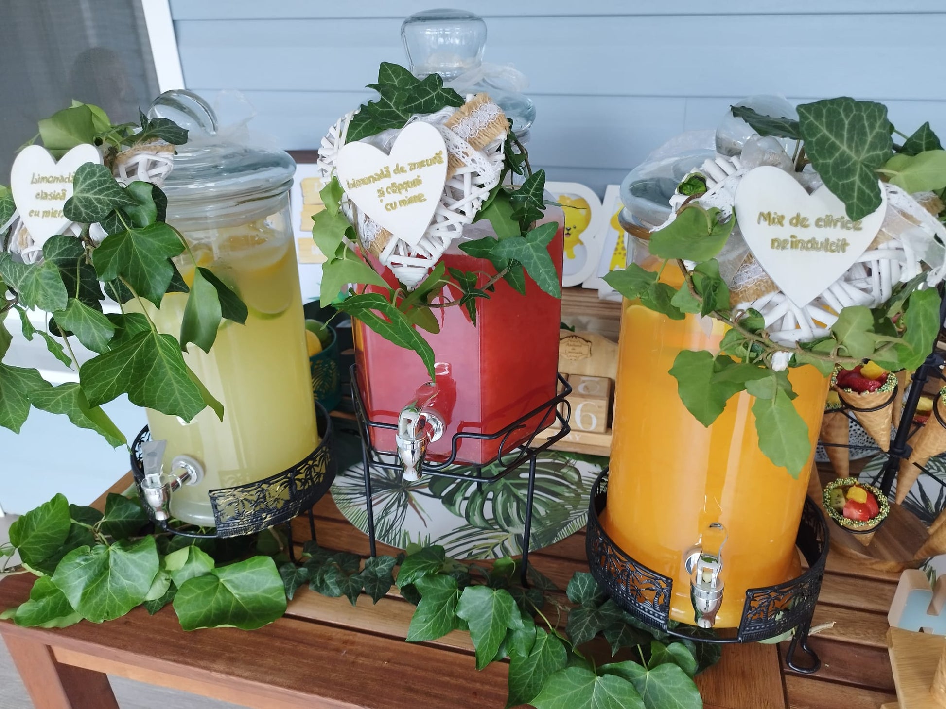 Stand de limonadă decorat cu iederă naturală, conținând limonadă clasică cu miere, mix de citrice neîndulcit și limonadă de zmeura si capsuni cu miere.