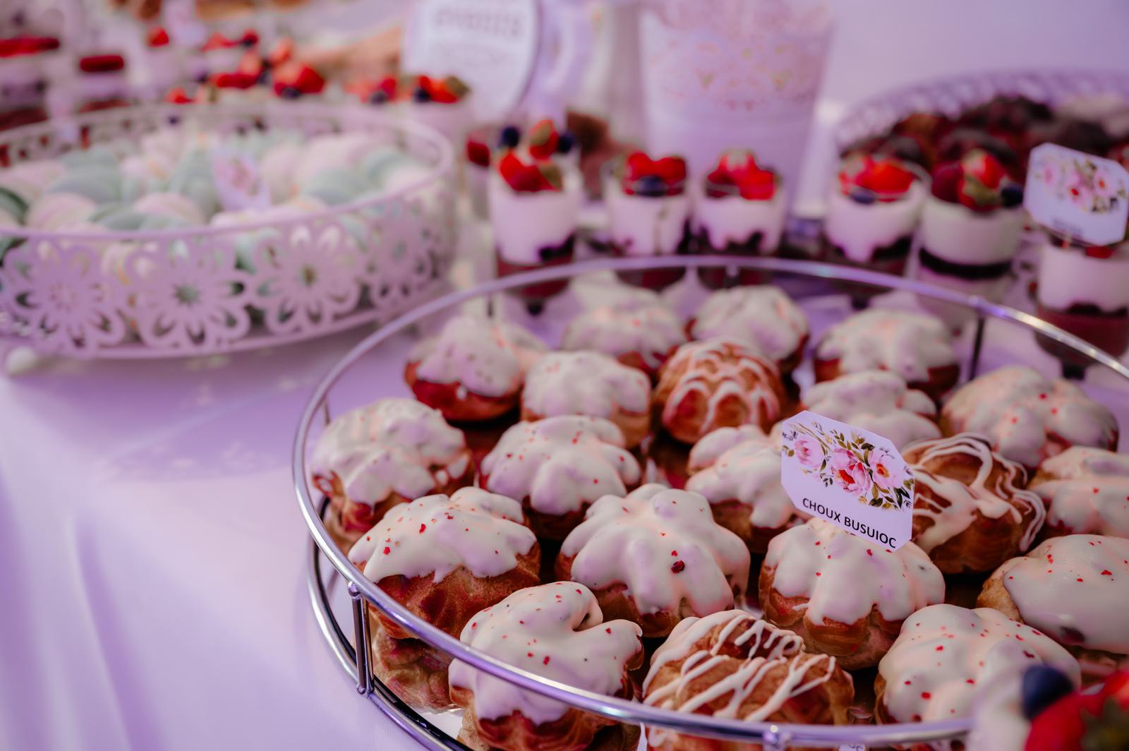 Choux cu busuioc glazurate cu ciocolată albă, expuse elegant pe un candy bar semnat Atelierul de Limonadă.