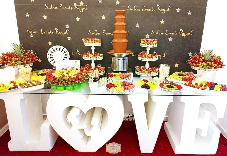 Fruit bar cu fântână de ciocolată belgiană și aranjamente spectaculoase din fructe proaspete, decorat cu litere volumetrice LOVE pentru un eveniment elegant.
