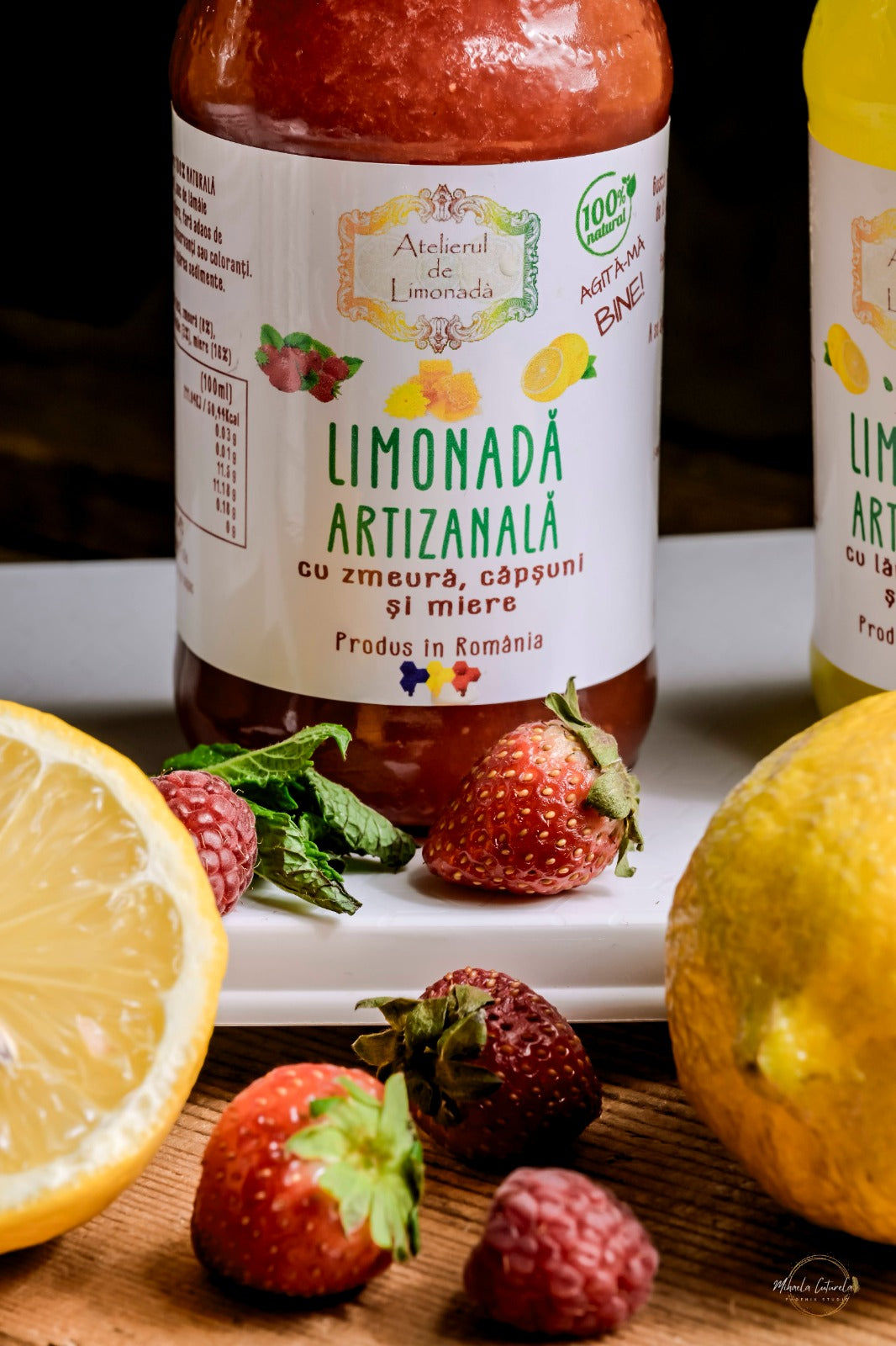 Close-up cu sticla de limonadă artizanală cu zmeură, căpșuni și miere, un produs 100% natural.