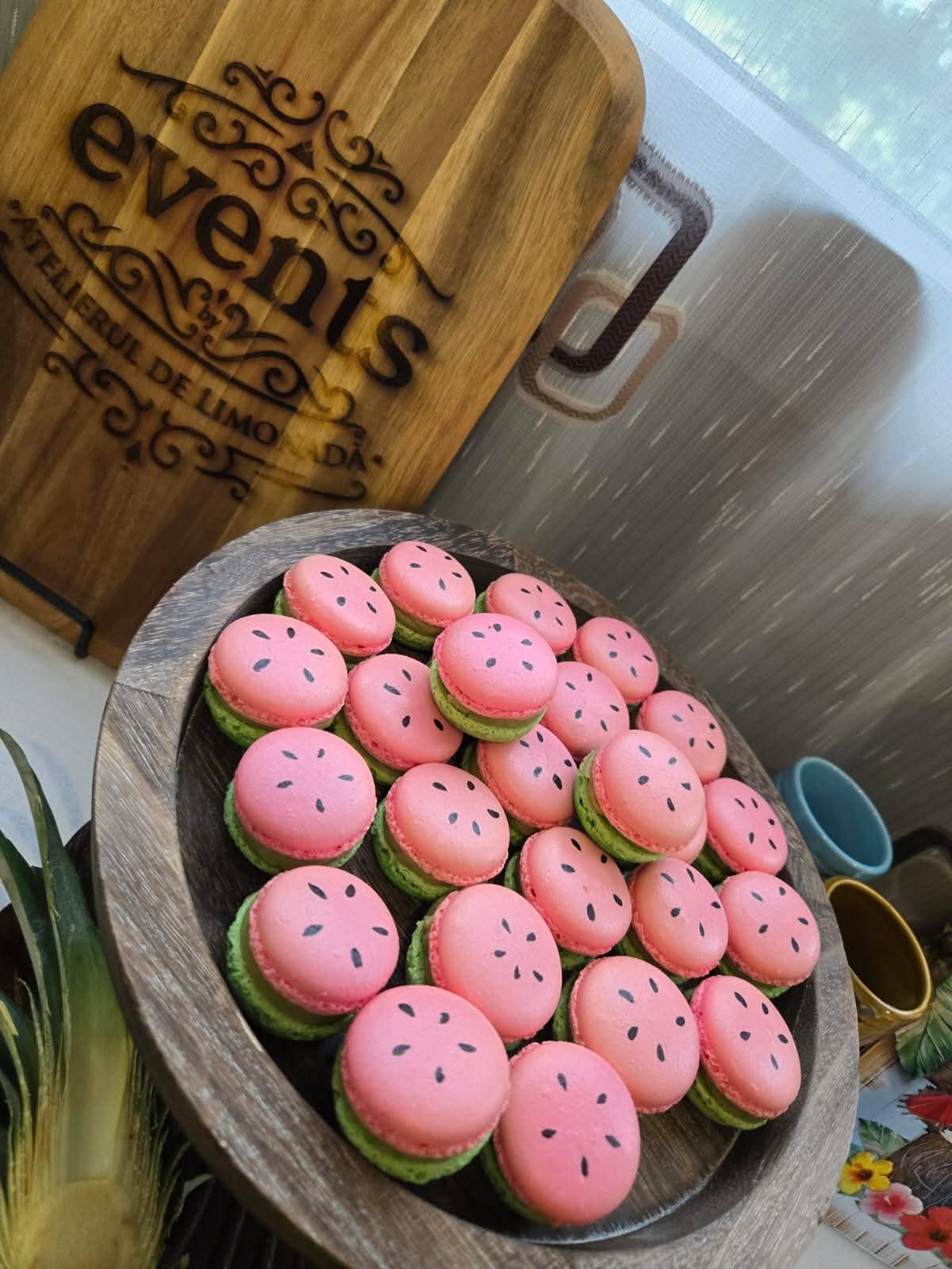 Macarons artizanali roz și verzi, decorați ca felii de pepene verde, pentru o petrecere corporate.