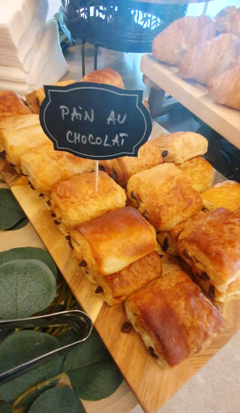 Platou cu pain au chocolat proaspete, o opțiune delicioasă pentru micul dejun sau pauza de cafea la evenimente corporate.