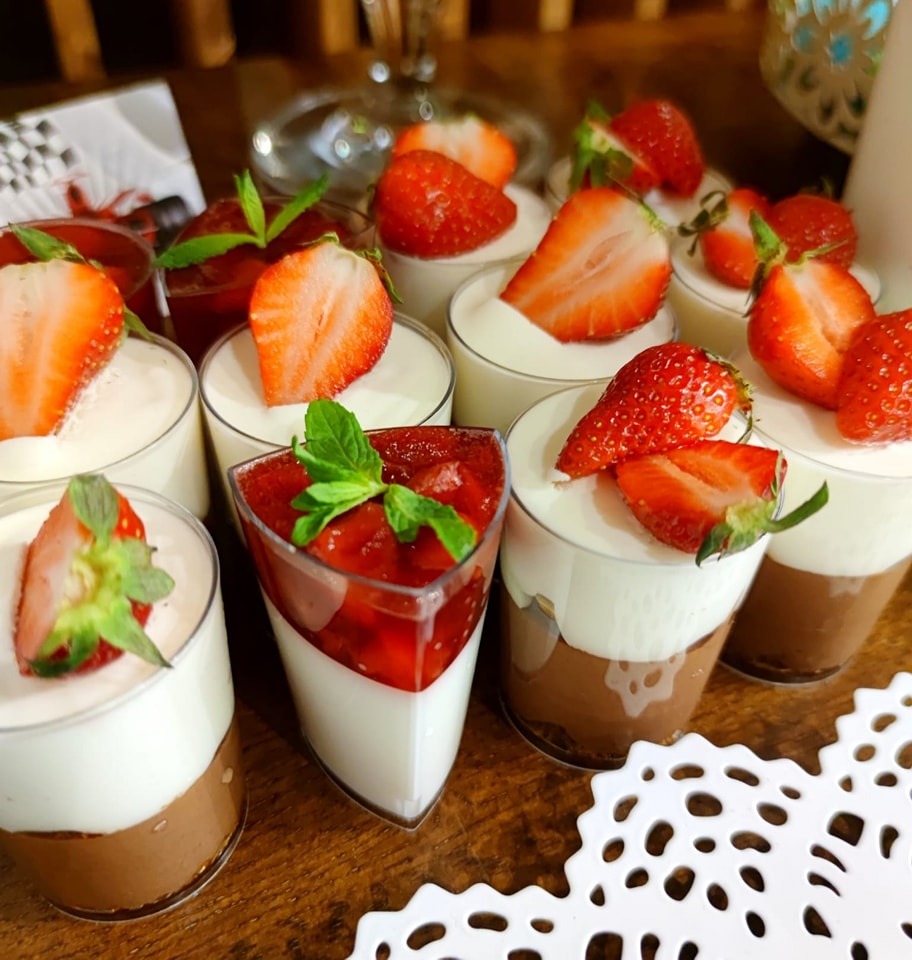Panna cotta cu strat de ciocolată și căpșuni proaspete, servită festiv în pahare individuale, parte din candy bar-ul Atelierul de Limonadă.