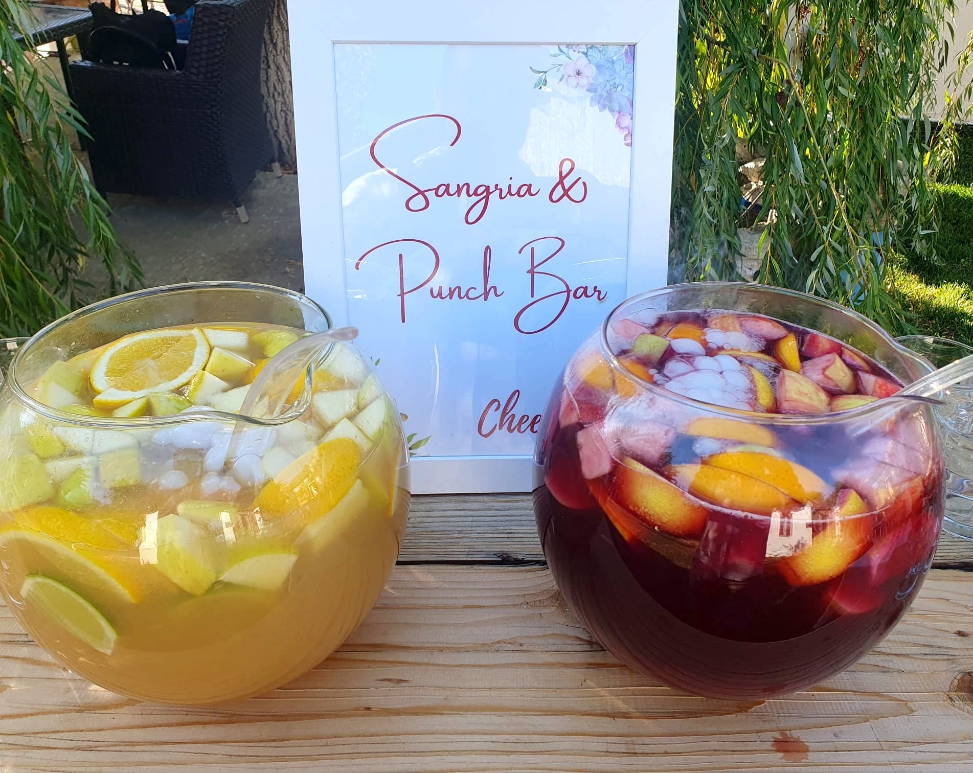 Două boluri elegante cu sangria și punch, pline de fructe proaspete și gheață, pregătite pentru servire la un eveniment organizat de Atelierul de Limonadă.