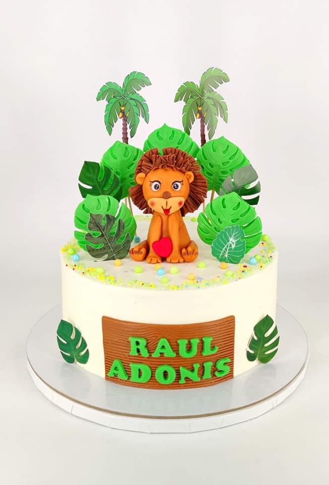 Tort personalizat pentru băieți cu numele Raul Adonis, decorat cu un leu simpatic care ține o inimioară, înconjurat de palmieri și frunze de junglă.